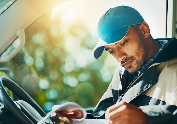 man in car looking at clipboard